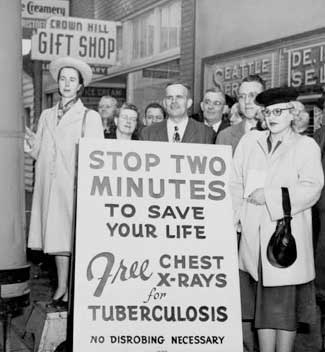 	Crowd standing by sign advertising free chest x-ray screening on Crown Hill, Seattle, ca. 1955