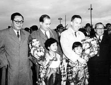 Senator Henry M. Jackson and Congressman Ed Edmudson posing with Mayor Kim Tae Sin and Minister of Education, Lee Sung Kun, and flower girls during a tour of military installations in the Far East. K-16 Airport, Seoul, Korea, November 28, 1955