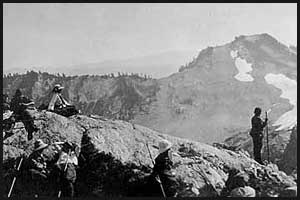 Men and women resting on rocks during climb of Mount Christie