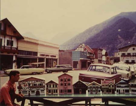 Artist Kit Clark with architectural models of the first six buildings under construction