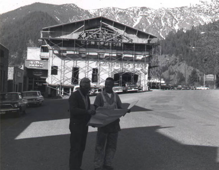 Construction workers holding plans in front of the Tannenbaum building during Bavarian remodel