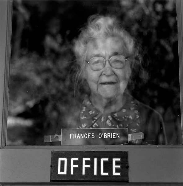 Frances O'Brien looking out her office-door window, Blue River, Oregon