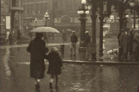 Sepia photograph of people walking in the rain