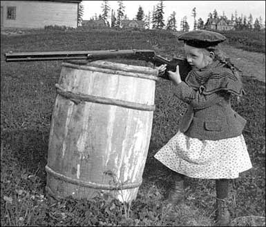 Miriam Kiehl shooting over a barrel, probably at Fort Lawton, 1900