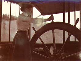 Mabel Meed at the wheel of the steamboat PROSPECTOR.