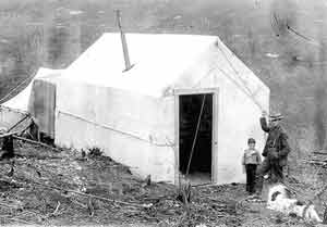 Man, boy, and dog outside the Slayden cabin, Adams Hill, 1899