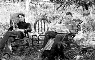 Howard Darlington and Frank Atkins reading outdoors, 1893